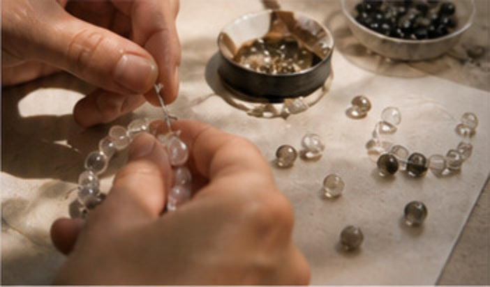 Hands assembling a crystal bracelet