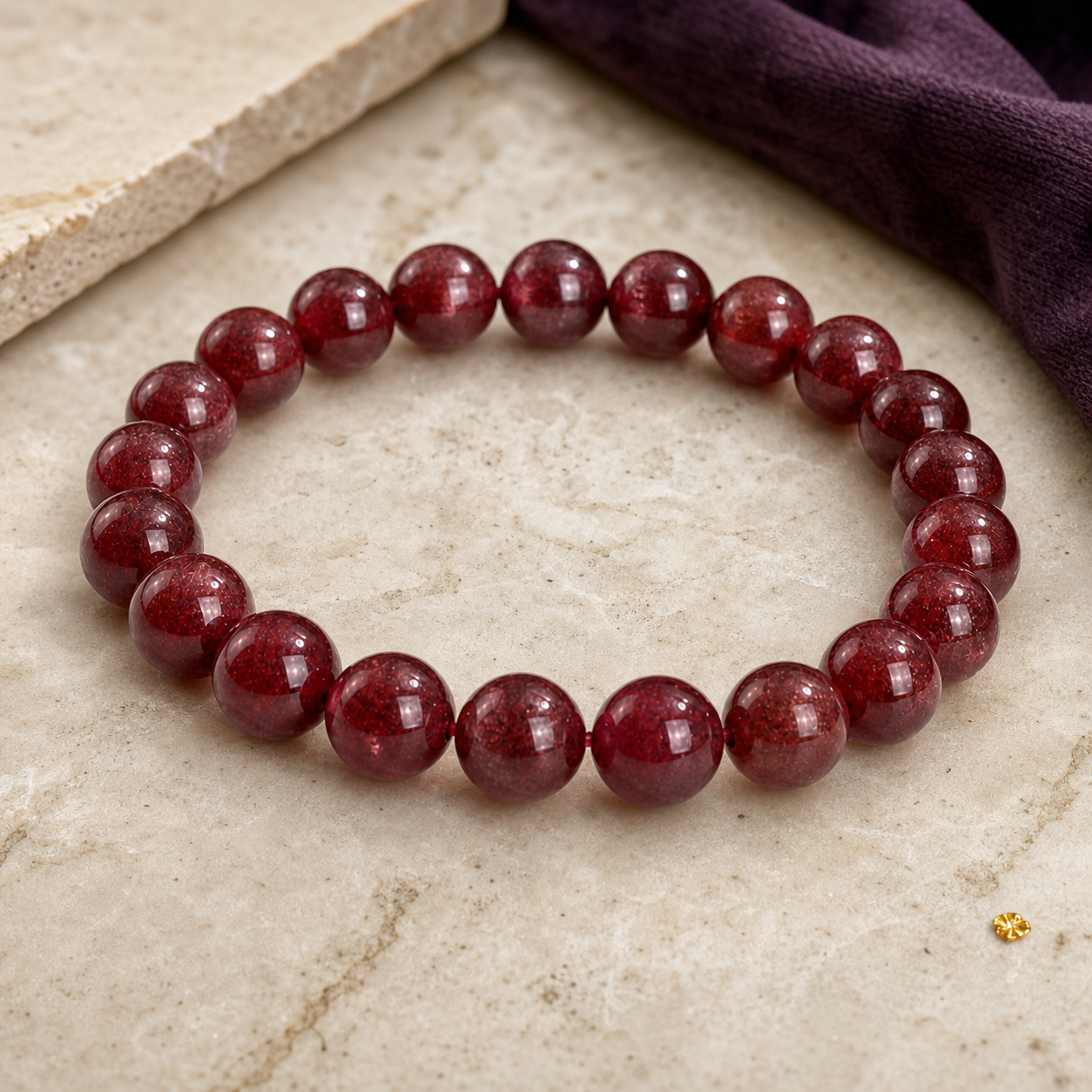 Deep red finished bracelet on a warm stone surface